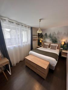 a bedroom with a large bed and a window at Auberge du Vieux Lanas Logis Hotel Restaurant in Lanas