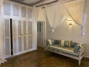 ein Wohnzimmer mit einem Sofa in einem Zimmer mit Vorhängen in der Unterkunft Fulvia House in Malindi