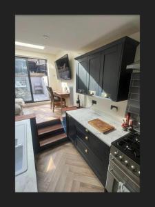 a kitchen with black cabinets and a dining room at Remarkable 3-Bed House in the centre of Guildford in Guildford