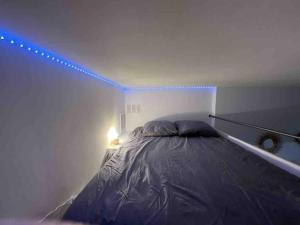 a bedroom with a bed with a blue light at Loft - centre historique in Villefranche-sur-Mer