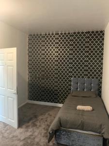 a bedroom with a bed with a accent wall at Single Room in Oldham