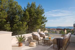 a patio with chairs and a table on a balcony at Villa Allegra Istriana in Fazana with sea view & spa in Fažana