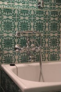 baño con bañera y papel pintado verde y blanco en Villa Weiss, en Attersee am Attersee