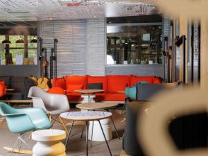 ヴァランスにあるibis Valence Sudのカラフルな家具、テーブル、椅子が備わるレストランを併設しています。