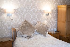 a bedroom with a bed with two pillows on it at The Ship Inn in Holy Island