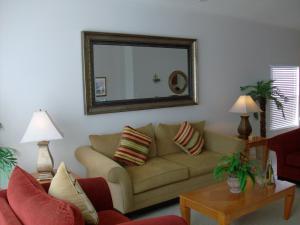 Private Pool Homes في كيسيمي: غرفة معيشة مع أريكة ومرآة