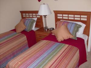 Private Pool Homes في كيسيمي: سريرين توأم في غرفة بها مصباح