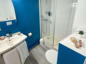 een blauwe badkamer met een wastafel en een douche bij ibis Douai Centre in Douai