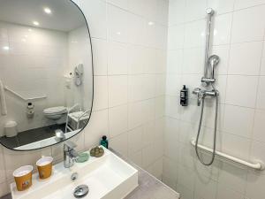 a bathroom with a shower and a sink and a mirror at ibis Douai Centre in Douai