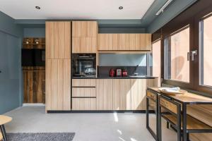 a kitchen with wooden cabinets and a table at Hamac Suites - Suite Parc 1 in Villeurbanne