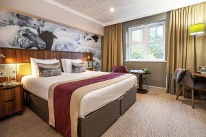 a hotel room with a large bed and a window at Castle Green Hotel In Kendal, BW Premier Collection in Kendal