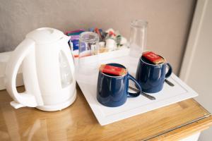 a tea kettle and two cups on a table at The Ship Inn in Holy Island