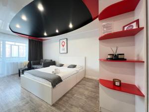 1 dormitorio con cama blanca y estanterías rojas en Студия в центре, en Pavlodar