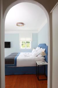 a bedroom with a blue and white bed and a table at Villa Weiss in Attersee am Attersee
