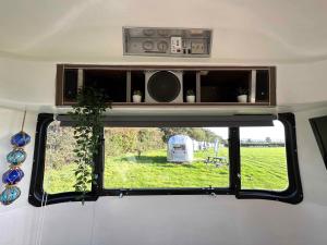 a window in a camper with a view of a field at Retro Staycations in Ryde