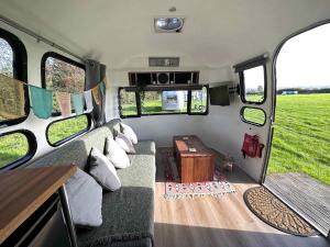 uma vista interior de uma caravana com um sofá e uma mesa em Retro Staycations em Ryde