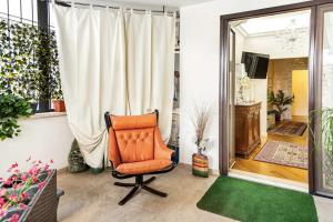 an orange chair in a room with a window at Menotti elegant Apartment in Rome