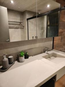 a bathroom counter with a sink and a mirror at Luxuoso Studio particular reformado no Grand Mercure in Brasilia