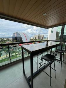 a table and chairs on a balcony with a view of a stadium at Luxuoso Studio particular reformado no Grand Mercure in Brasília