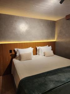 a bedroom with a large bed with white sheets and pillows at Luxuoso Studio particular reformado no Grand Mercure in Brasília