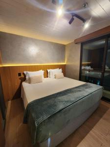 um quarto com uma cama grande e uma ventoinha de tecto em Luxuoso Studio particular reformado no Grand Mercure em Brasília