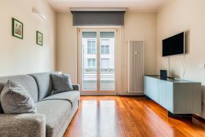 a living room with a couch and a television at Milano Via Del Fusaro 4 PAX Wi-Fi in Milan