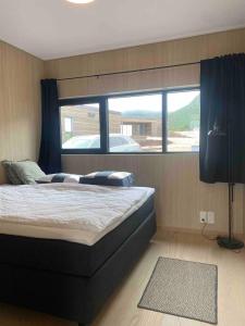 a bedroom with a large bed with a large window at New lodge at seaside, near Henningsvær Lofoten in Kleppstad