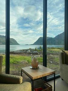 a room with a table and a view of the water at New lodge at seaside, near Henningsvær Lofoten in Kleppstad
