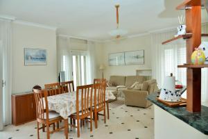 een keuken en een woonkamer met een tafel en stoelen bij Frisio Reef Apartment- Sea View in Trani