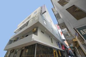 a tall white building with a balcony on a street at Grand Empire Suites By Delhi Airport in New Delhi