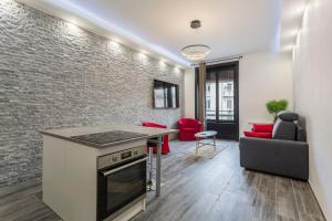 uma cozinha e sala de estar com uma parede de tijolos em Hamac Suites-Suite les Brotteaux em Lyon