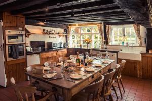 a kitchen with a long wooden table and chairs at Toad Hall in Swilland