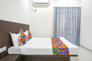a bedroom with a bed and a window at FabHotel Om Sai in Nashik