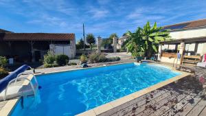 a large blue swimming pool next to a house at Gîtes de 2 à 11 personnes au Domaine d'USSON in Échebrune