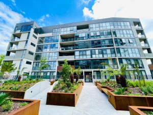an office building with plants in front of it at Brand New Stylish 1BR Apartment, Specious Space, Free Parking, Self Check-in in Canberra