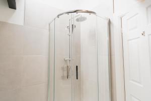 a shower with a glass door in a bathroom at Newly Renovated 4 bed in Tarvin, Near Chester - Sleeps up to 15 in Tarvin