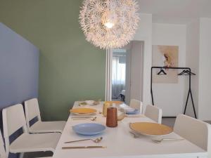 uma sala de jantar com uma mesa branca e um lustre em Ampio e nuovissimo Trilocale 6 pax centrale em San Benedetto del Tronto