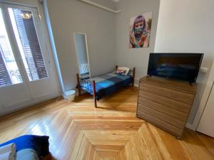 a living room with a couch and a flat screen tv at Arc House Madrid - Puerta del Sol Only Adults in Madrid