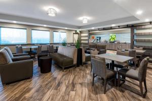a restaurant with tables and chairs and a bar at La Quinta by Wyndham Fairbanks Airport in Fairbanks