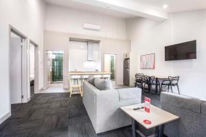 a living room with a couch and a table at Nightcap at Ferntree Gully Hotel Motel in Fern Tree Gully