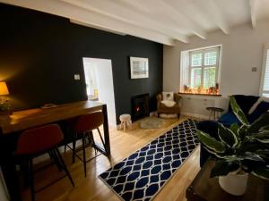 a living room with a desk and a table with a plant at Clover Neuk Mews Cottage, 34a Main Road in Fairlie