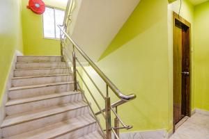 a staircase with a metal railing in a room with green walls at FabHotel Divine Chariot in Kolkata