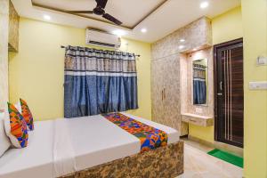 a bedroom with a bed and a window at FabHotel Divine Chariot in Kolkata