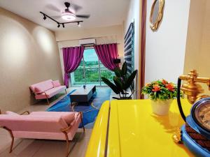 salon z żółtym stołem i różowymi meblami w obiekcie Pavilionvillie M1T692 by irainbow w mieście Ipoh