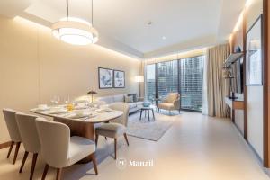 een eetkamer en een woonkamer met een tafel en stoelen bij Address Opera - Lux 3 BR with Full Burj Khalifa View near Dubai Mall in Dubai