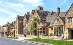 a row of large stone buildings on a street at Inviting 3-Bedroom Lodge in Ashton Under Hill in Evesham