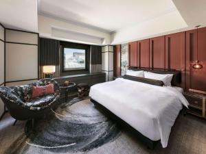 sypialnia z dużym łóżkiem i krzesłem w obiekcie Hotel Sosei Sapporo MGallery Collection w mieście Sapporo