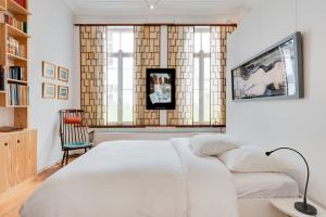 een slaapkamer met een wit bed en een groot raam bij Saint Catherine Art Residence in Brussel
