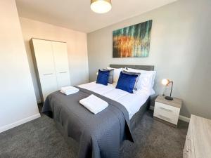 1 dormitorio con 1 cama grande con almohadas azules en Turnstile Place by Blue Skies Stays, en Middlesbrough