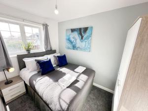 Dormitorio pequeño con cama con almohadas azules en Turnstile Place by Blue Skies Stays, en Middlesbrough